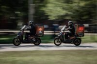 Motocicletas elétricas conectadas promovendo publicidade em áreas urbanas